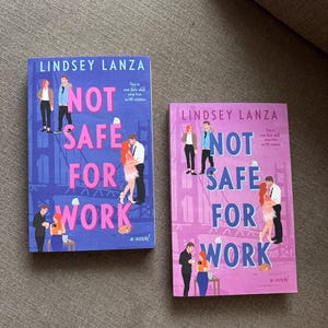 May include: Two copies of the novel "Not Safe For Work" by Lindsey Lanza. The book covers feature illustrations of people and the title in large, bold letters. One cover is blue, the other is pink.