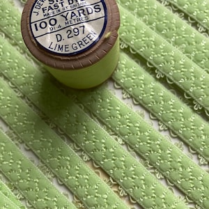 May include: A spool of lime green thread labeled "Sylko Fast Dye" with 100 yards (91.4 meters) of thread. The spool is made in Great Britain and has a label with the number D. 297.