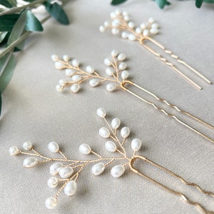 Braut-Haarschmuckset bestehend aus drei goldenen Haarspangen mit weißen Perlen. ca. 6,5 cm lang, 6,5 cm breit. Zarte Perlen verleihen dem Schmuck eine feine Eleganz. Ideal für Bräute, Brautjungfern und Trauzeuginnen