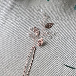 Anmutige Haarspange in Roségold mit filigranen Blattmustern und zarten Perlen. Perfekt als Brautschmuck oder für Brautjungfern. Vielseitig einsetzbar als Haarnadel, Schiebehaarklammer oder Haarkamm für elegante Hochsteckfrisuren."