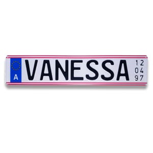 Può includere: Targa bianca con una bandiera blu dell'Unione Europea e la lettera "A" sul lato sinistro. Il nome "VANESSA" è stampato in lettere nere al centro. I numeri "12 04 97" sono stampati sul lato destro.