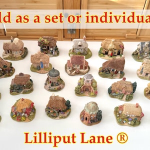 May include: A selection of miniature Lilliput Lane cottages, featuring detailed designs and thatched or tiled roofs. The cottages are in various colors, with intricate landscaping and the text "Lilliput Lane ®".