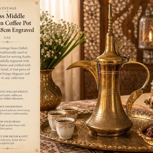 May include: A vintage brass Middle Eastern coffee pot, 28cm engraved, traditionally used for Arabic coffee. The gold-coloured pot features intricate patterns and a classic Dallah silhouette. The pot is displayed with small cups and a tray of dates.