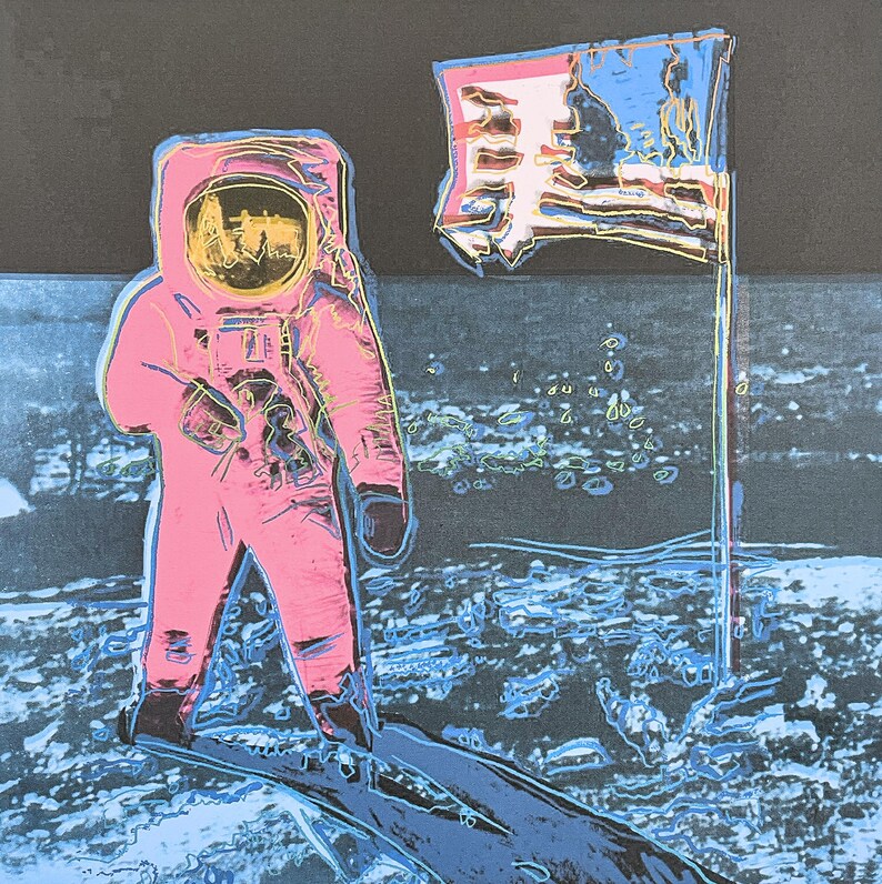 Puede incluir: Impresi&oacute;n de arte pop de un astronauta con un traje espacial rosa de pie sobre una superficie lunar azul y gris junto a una bandera estadounidense. El casco del astronauta refleja una imagen amarilla y negra. La bandera es roja, blanca y azul.