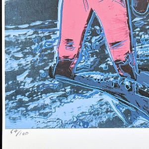 Puede incluir: Estampa de arte pop de un astronauta con un traje espacial rosa, sobre un fondo azul y negro. La estampa est&aacute; numerada 64/100. La obra de arte est&aacute; firmada por Georges Israel Editeur.