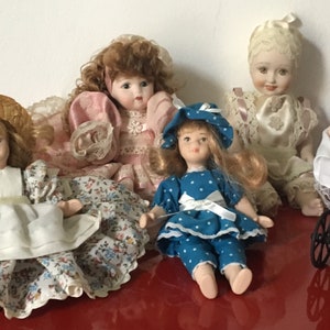 five ancient and splendid collectible dolls in biscuit porcelain with enchanting hats and dresses in lace and fine fabric.