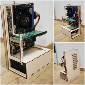 Könnte beinhalten: Ein Computergehäuse aus Holz mit einem Motherboard, einer Grafikkarte und anderen sichtbaren Komponenten. Das Gehäuse ist vorne und seitlich geöffnet und zeigt die inneren Komponenten. Das Gehäuse ist aus hellem Holz und hat ein schlichtes Design.