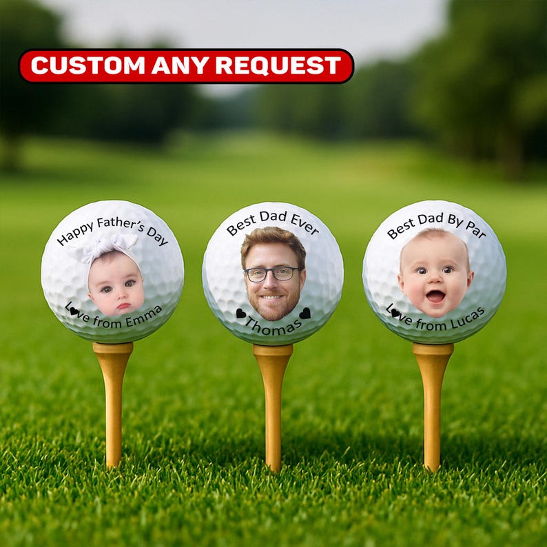 May include: Three personalized golf balls on wooden tees, each with a different design. One ball says "Happy Father's Day" with a baby's face, another says "Best Dad Ever" with a man's face, and the last says "Best Dad By Par" with a baby's face. The text "Custom Any Request" is at the top.