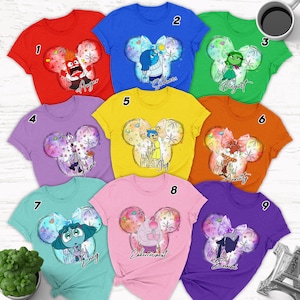 May include: Nine different t-shirts featuring a cartoon character from the movie Inside Out. Each shirt has a different character and color. The characters are Anger, Sadness, Disgust, Fear, Joy, Anxiety, Envy, Embarrassment, and Shame.