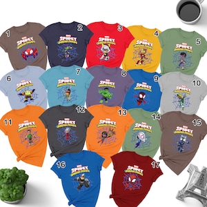 May include: A set of 17 t-shirts featuring different Marvel characters from the Spidey and His Amazing Friends cartoon. The shirts are in various colors, including red, blue, green, orange, and gray. Each shirt features a different character, such as Spidey, Ghost-Spider, Hulk, and Green Goblin.