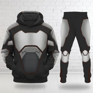 May include: A black hoodie and matching pants set with a futuristic design. The hoodie and pants feature a silver and gray panel design with red trim. The hoodie has a hood and a front pocket. The pants have a matching design.