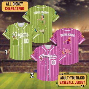 May include: Baseball jerseys featuring Disney characters. One green jersey has "Drizella" and the number "00". Another green jersey has a Disney character on the front and back. A pink jersey has "Anastasia" and the number "00". A pink jersey has a Disney character on the front and back.