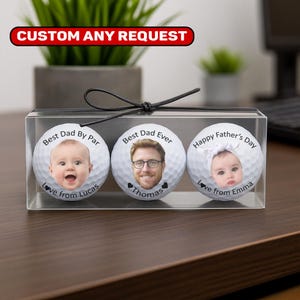 May include: A clear box contains three personalized golf balls. Each ball features a photo and text: "Best Dad By Par," "Best Dad Ever," and "Happy Father's Day." The text "Love from Lucas," "Thomas," and "Love from Emma" is also present. The top banner reads "CUSTOM ANY REQUEST."