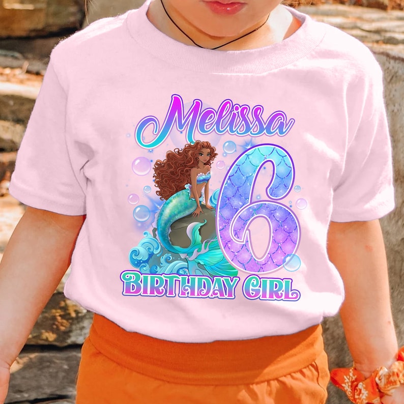 Puede incluir: Camiseta rosa con un gr&aacute;fico de sirena, el n&uacute;mero 6 y el texto "Melissa Birthday Girl".