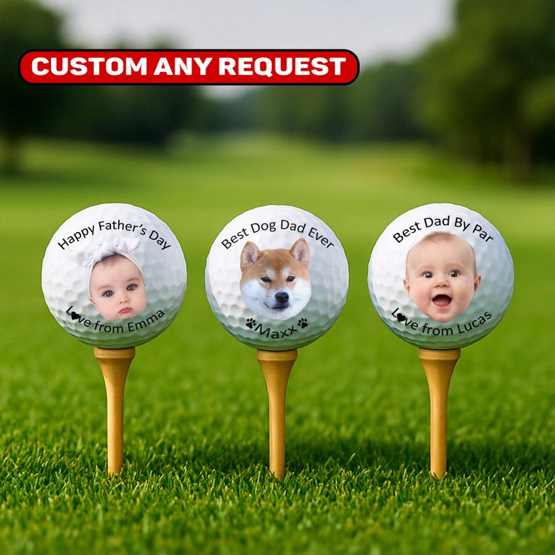 May include: Three personalized golf balls on wooden tees, each with a unique design. One features a baby with "Happy Father's Day" and "Love from Emma." Another has a dog with "Best Dog Dad Ever" and "Maxx." The third shows a baby with "Best Dad By Par" and "Love from Lucas."