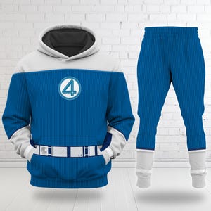 May include: Blue hoodie and matching trousers set. The hoodie features a white and blue design with a circular emblem and the number 4. The trousers are blue with white cuffs. The set is designed with a superhero theme.