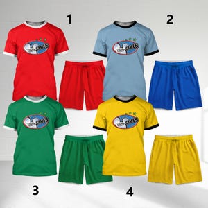 May include: Four sets of athletic wear, each consisting of a t-shirt and shorts. The t-shirts are red, light blue, green, and yellow, with white or black trim. Each shirt features a logo that says "Disney Games". The shorts match the shirt colors.