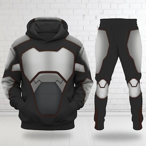 May include: A black hoodie and matching pants set with a futuristic design. The hoodie and pants feature a silver and gray panel design with red trim. The hoodie has a front pocket and a hood. The pants have a matching design.