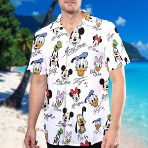 May include: White short-sleeved button-down shirt with a colourful all-over print of Mickey Mouse, Minnie Mouse, Donald Duck, Daisy Duck, Goofy, and Pluto. Each character has their signature underneath their image.