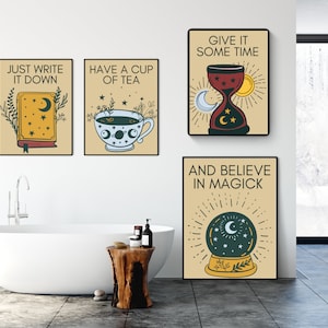 May include: Four beige framed prints with black text and illustrations. The prints feature quotes about writing, tea, time, and magic. The prints are hanging on a white wall in a bathroom with a white bathtub and a wooden stool.