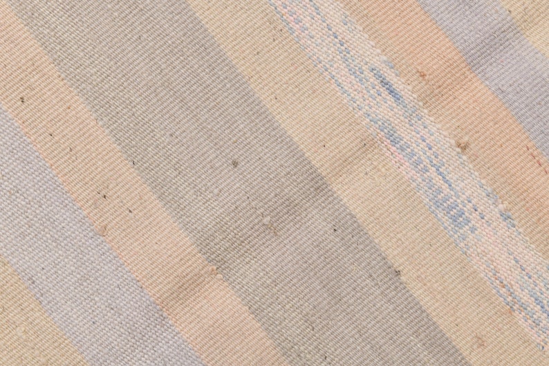 K&ouml;nnte beinhalten: Nahaufnahme eines gewebten Stoffes mit diagonalen Streifen in Beige-, Hellblau- und Rosat&ouml;nen.