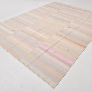 K&ouml;nnte beinhalten: Ein handgewebter Teppich mit einem gestreiften Muster in Beige-, Rosa- und Graut&ouml;nen. Der Teppich hat einen abgenutzten, Vintage-Look.