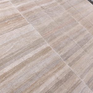 Pu&ograve; includere: Un tappeto a strisce beige e bianco con una trama tessuta. Il tappeto ha una lucentezza discreta e un design contemporaneo.