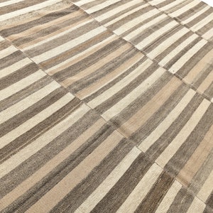 May include: A striped rug with a patchwork design in shades of brown and beige.