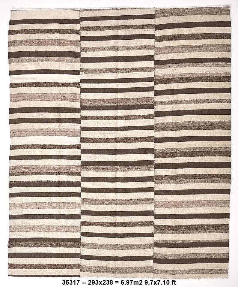 Op de afbeelding: Een rechthoekig tapijt met horizontale strepen in bruin-, beige- en cr&egrave;metinten. Het tapijt heeft een gestreept patroon en is verdeeld in drie verticale secties. Afmetingen: 293x238 cm.