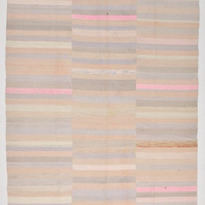 K&ouml;nnte beinhalten: Ein gewebter Teppich mit einem gestreiften Muster in Beige-, Rosa- und Graut&ouml;nen. Der Teppich ist aus Naturfasern gefertigt und hat einen rustikalen, handgefertigten Look.