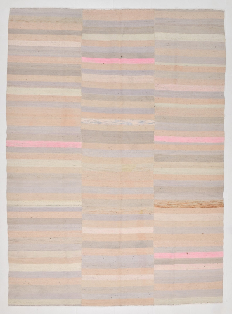 K&ouml;nnte beinhalten: Ein gewebter Teppich mit einem gestreiften Muster in Beige-, Rosa- und Graut&ouml;nen. Der Teppich ist aus Naturfasern gefertigt und hat einen rustikalen, handgefertigten Look.