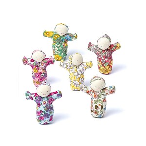 Peut inclure: Six petites poupées en tissu avec des visages blancs et des robes à motifs floraux de différentes couleurs, dont rose, jaune et vert. Les poupées ont les bras tendus et un design simple, parfait pour les enfants.
