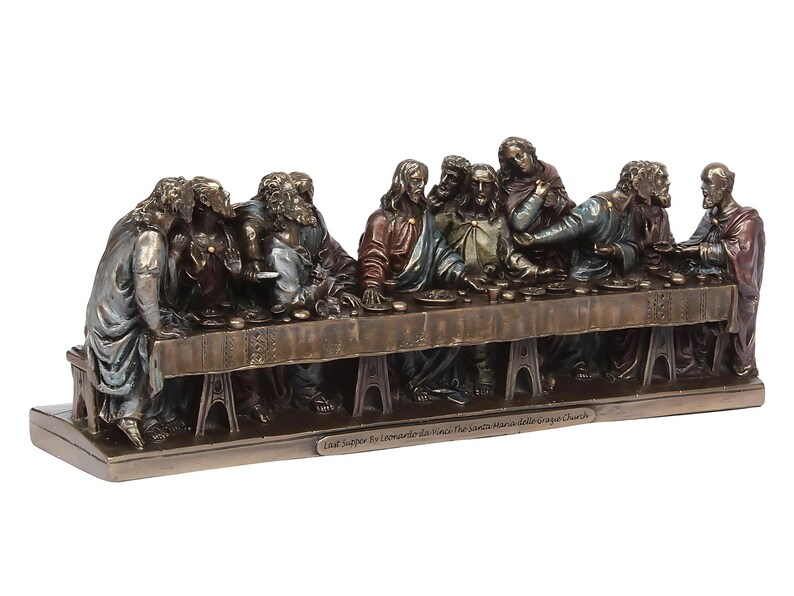 May include: A bronze sculpture depicting Leonardo da Vinci's The Last Supper, featuring 13 figures seated around a table. The sculpture is a detailed replica of the famous fresco in the Santa Maria delle Grazie church in Milan, Italy.