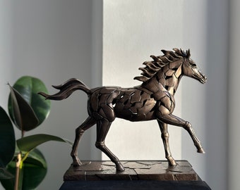 May include: A bronze sculpture of a horse with a fragmented, geometric design. The horse is in a running pose with its head turned to the side. The sculpture is on a dark brown base.