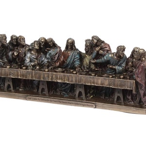 May include: A bronze sculpture depicting Leonardo da Vinci's The Last Supper, featuring 13 figures seated around a table. The sculpture is detailed with realistic features and painted in muted tones of brown, gold, and blue. The base of the sculpture is inscribed with "Last Supper by Leonardo da Vinci The Santa Maria delle Grazie Church."