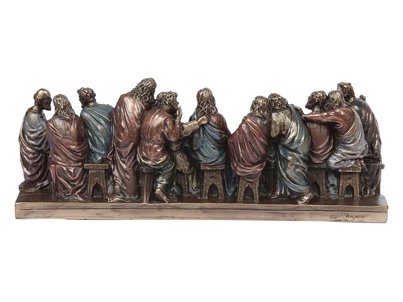 May include: A bronze sculpture depicting the Last Supper, featuring 13 figures seated around a table. The figures are detailed and realistic, with intricate clothing and facial expressions. The sculpture is mounted on a wooden base.