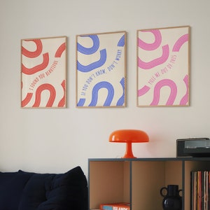 May include: Three framed prints with colorful abstract designs and text. The prints are hung on a white wall. The text on the prints reads "I found you beautiful", "If you don't know, don't worry", and "Pull me out of this".