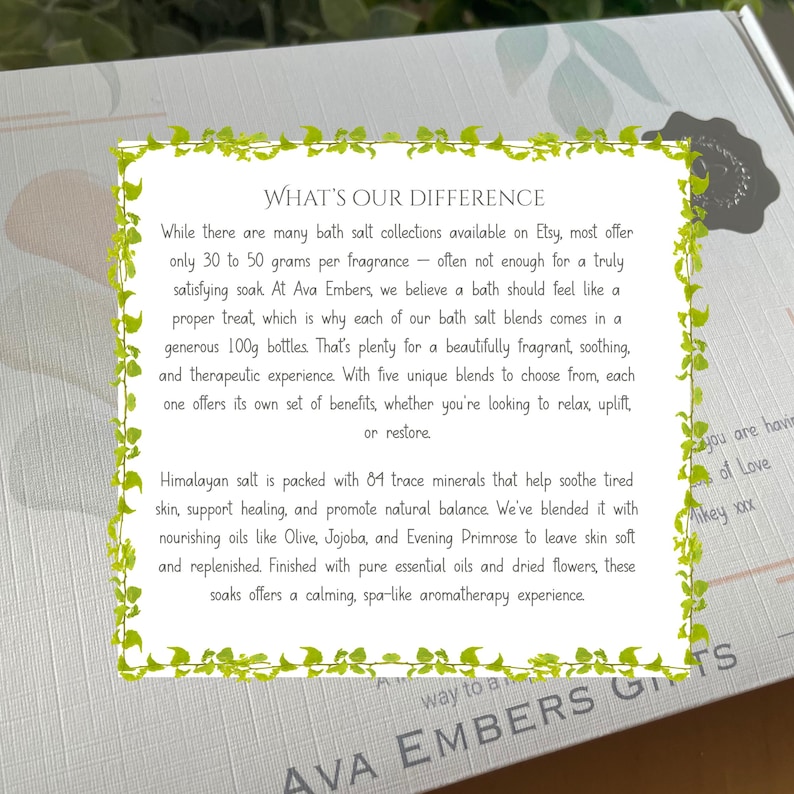 May include: A gift box with text that reads "WHAT'S OUR DIFFERENCE" and "AVA EMBERS GIFTS". The text describes bath salt blends with Himalayan salt, essential oils, and dried flowers. The box has a decorative green border.