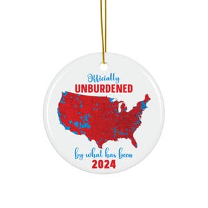 May include: A white ceramic ornament with a red, white, and blue map of the United States. The text "Officially Unburdened by what has been 2024" is printed on the ornament.