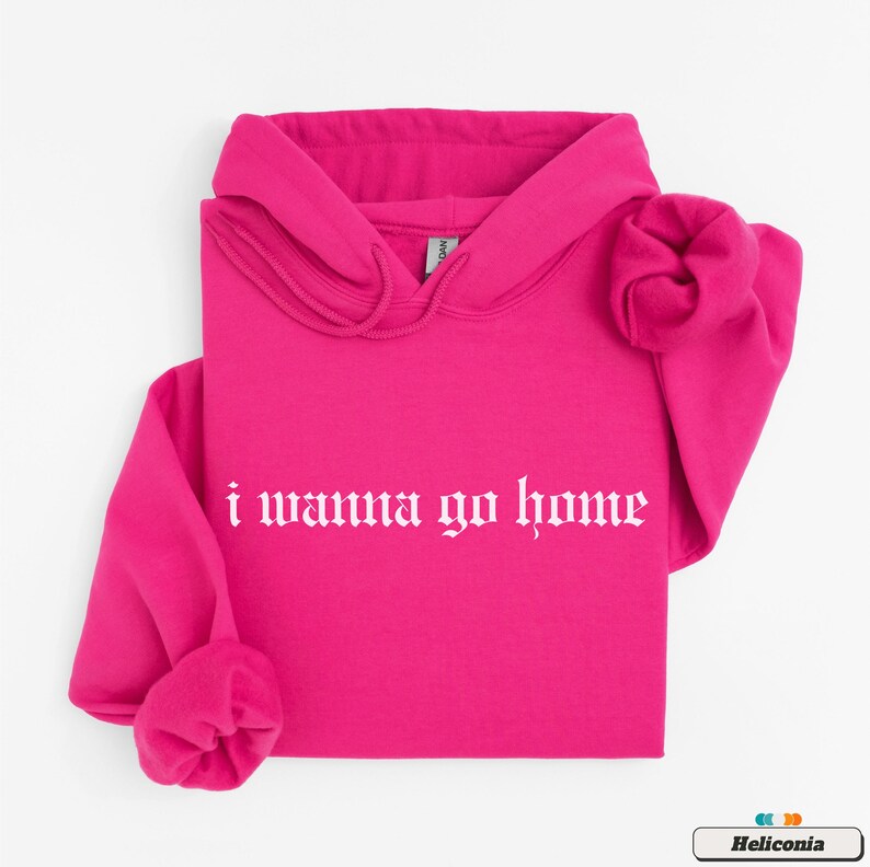 May include: A bright pink hoodie with the phrase "i wanna go home" in white gothic lettering.