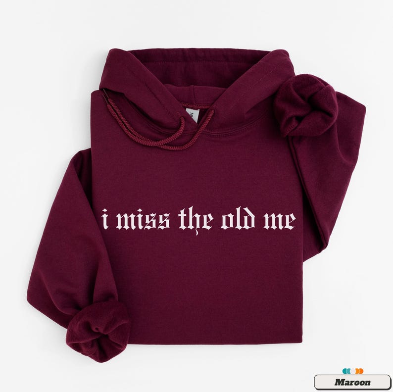 Puede incluir: Una sudadera con capucha color granate con el texto "i miss the old me" en fuente g&oacute;tica blanca.