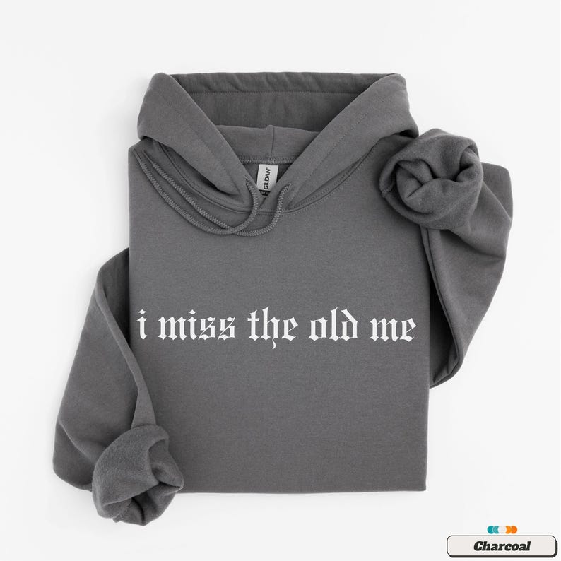 Puede incluir: Una sudadera con capucha de color gris carb&oacute;n con el texto "i miss the old me" impreso en blanco en la parte delantera.