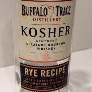 K&ouml;nnte beinhalten: Eine klare Glasflasche Buffalo Trace Kosher Rye Recipe Whiskey. Das Etikett zeigt den Namen der Brennerei, Produktdetails und Zertifizierungsinformationen. Das Etikett ist cremefarben und schwarz mit roten Akzenten. Die Flasche enth&auml;lt 750 ml Whiskey.