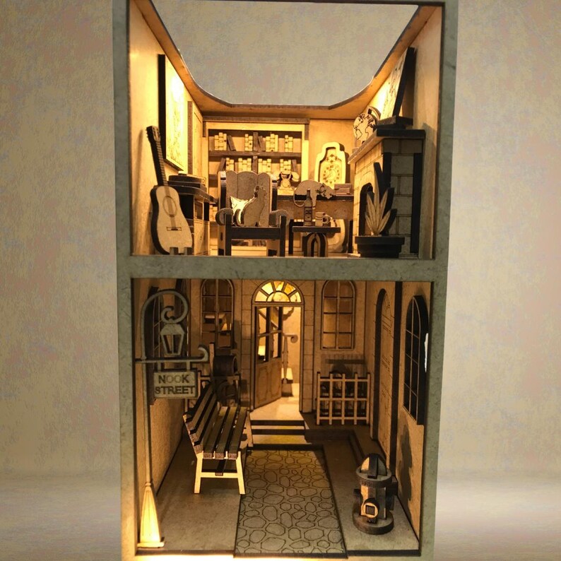 Peut inclure: Mod&egrave;le en bois d'un b&acirc;timent de deux &eacute;tages avec un magasin au rez-de-chauss&eacute;e et un espace de vie &agrave; l'&eacute;tage. Le magasin a une enseigne qui dit "Nook Street" et un banc &agrave; l'ext&eacute;rieur. L'espace de vie a une chemin&eacute;e, une biblioth&egrave;que et une guitare.