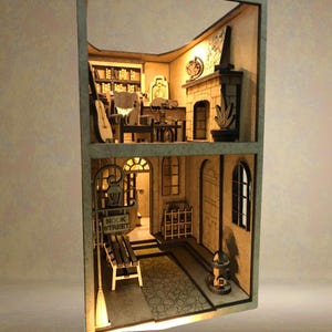 Peut inclure: Mod&egrave;le miniature en bois d'un b&acirc;timent de deux &eacute;tages avec une chemin&eacute;e, une biblioth&egrave;que et une enseigne indiquant "Nook Street". Le mod&egrave;le est &eacute;clair&eacute; de l'int&eacute;rieur, cr&eacute;ant une lueur chaleureuse.