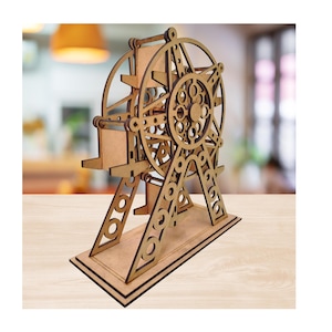 Könnte beinhalten: Ein Holzmodell eines Riesenrads mit aufwendigen Ausschnitten. Das Modell besteht aus hellbraunem Holz und hat eine rechteckige Basis. Das Rad hat ein kreisförmiges Design mit Speichen und einer zentralen Nabe. Die Stützen sind abgewinkelt und haben kreisförmige Aussparungen.