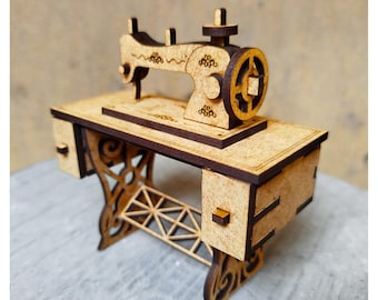 Könnte beinhalten: Miniatur-Nähmaschinenmodell aus Holz. Das Modell hat ein detailliertes Design mit dunkelbraunem Finish, einschließlich Rad, Nadel und Tisch mit Schubladen. Die Beine haben ein verziertes, durchbrochenes Design. Die Nähmaschine ist ein dekorativer Artikel.