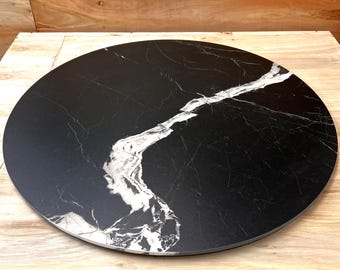 May include: Round black and white marble table top with a white vein pattern.