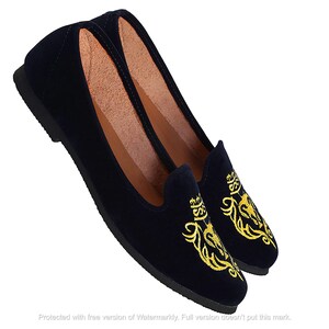 May include: Pair of navy blue velvet loafers with gold embroidered floral designs.