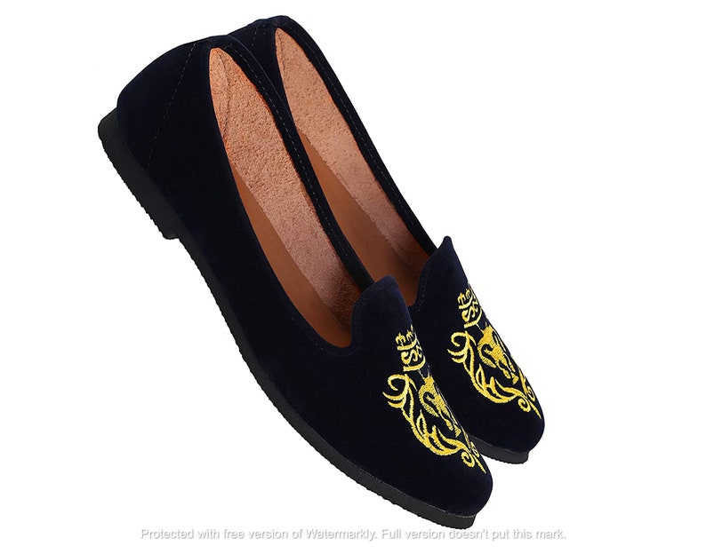 May include: Pair of navy blue velvet loafers with gold embroidered floral designs.